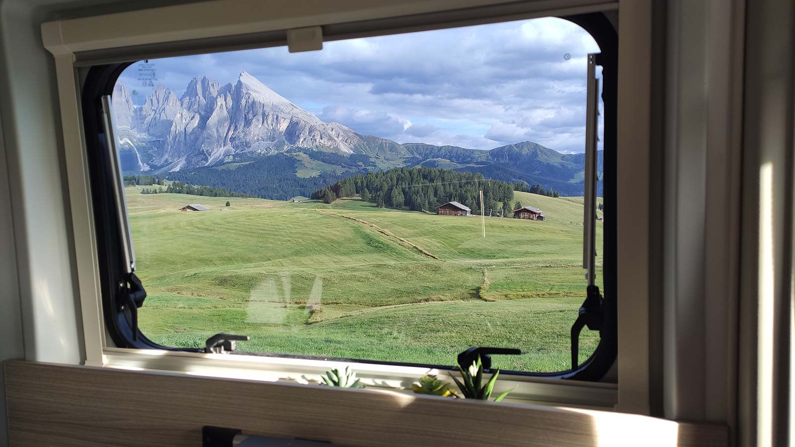 Foto d'un paissatge de muntanya des de l'interior de La Camper a través d'una finestra.